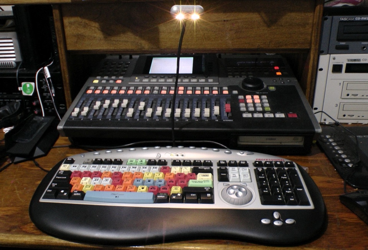 A color-coded video-editing keyboard beside an audio recording workstation, illustrating Apple's June 2026 on-device AI update to Final Cut Pro, Logic Pro, and Pixelmator Pro