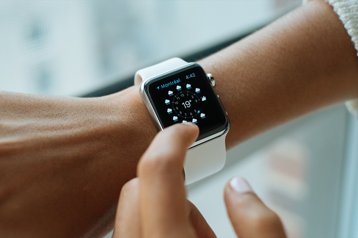 A person wearing an Apple Watch on their wrist, illustrating watchOS 27's new health features including perimenopause-aware Cycle Tracking