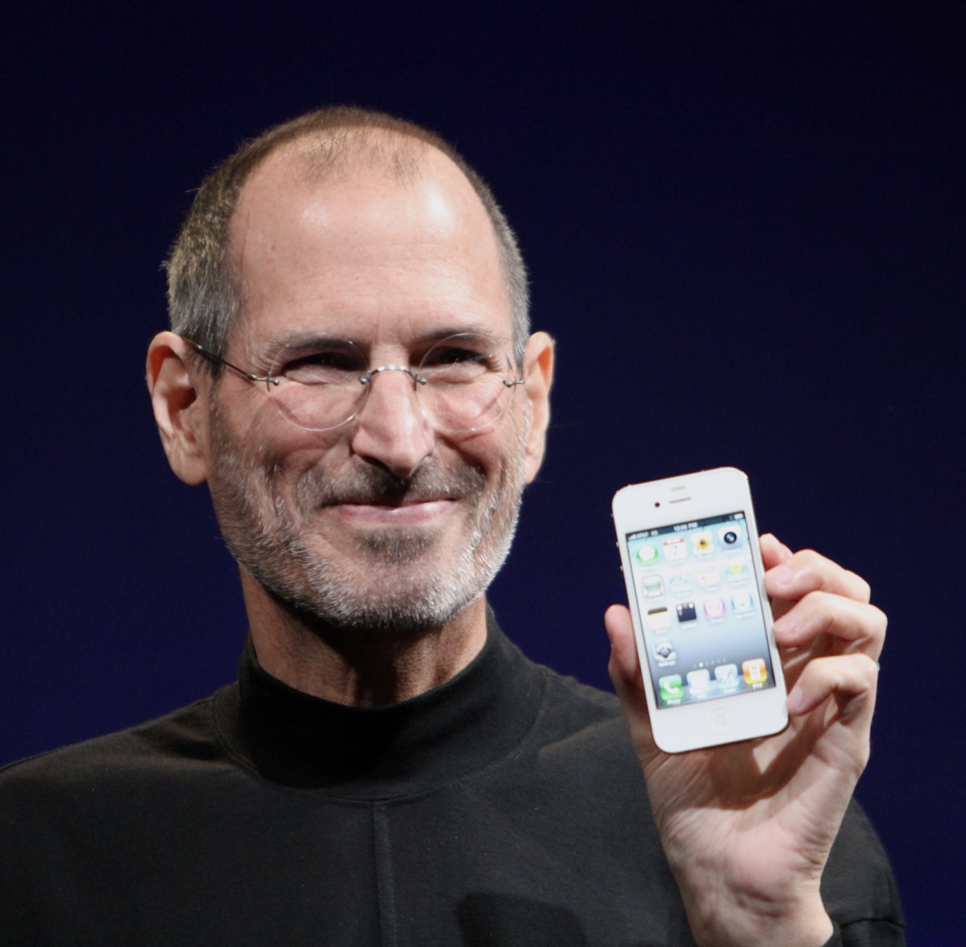 Steve Jobs holding the iPhone 4 at the 2010 Worldwide Developers Conference in San Francisco. The photograph captures Apple at the moment its iPhone era was fully established.